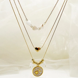 Detail of triple-layer gold necklace with heart, star, and moon enamel pendants