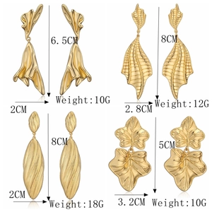 Detail view of gold maple leaf and irregular metal earrings with size measurements