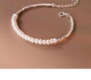 Macro detail of S925 sterling silver chain with white pearls and lobster clasp closure