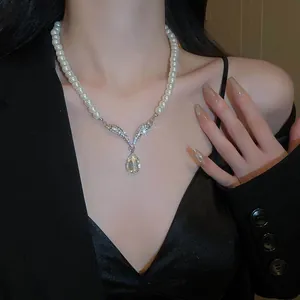 Elegant Y-shaped pearl necklace with a shimmering teardrop pendant on a model