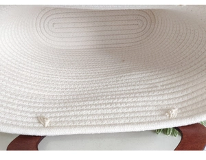 Close-up of woven cotton rope bag interior with brown wooden handles and sturdy stitch detail