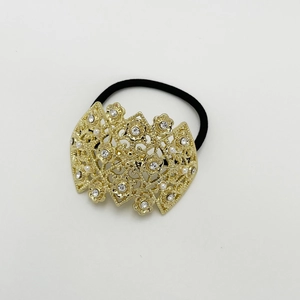 Detail of golden floral alloy hair ring with pearls and rhinestones on black elastic band