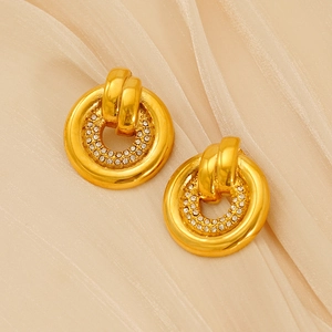 Close-up of gold titanium earrings with double-layered rhinestones on soft fabric