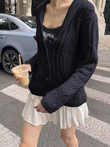 Detailed cable knit pattern on a navy blue long sleeve button-up cardigan for women