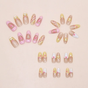 Detail view of almond press-on nails with cartoon bear, strawberry, and grid patterns