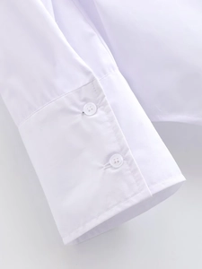 Detailed close-up of white shirt cuffs with double-button design and fine stitching