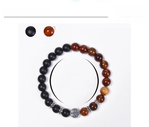 Detailed view of 8mm matte black and tiger eye beads bracelet with Tree of Life charm