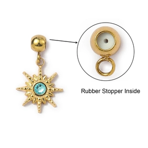 Detail of gold star pendant showing the rubber stopper inside and light blue crystal