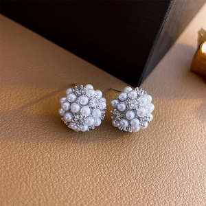 Macro shot of cluster pearl earrings with clear zircons and silver pin backing