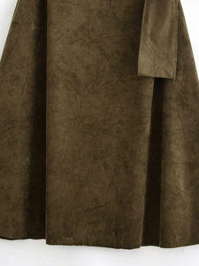 Macro shot of dark olive faux suede fabric texture and matte finish on an asymmetric dress