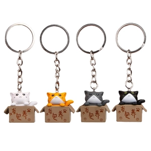 Set of four 3D cartoon cat keychains in boxes with heart patterns on white background