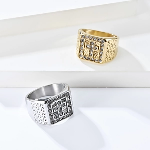 Detail of gold and silver cross square rings with pavé zircon stones on tiered platform