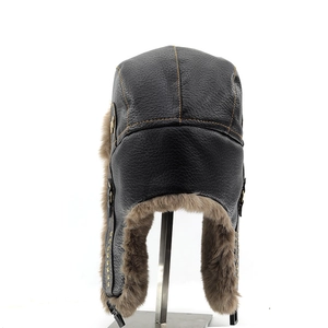 Close-up of black leather trapper hat featuring orange stitching and thick brown faux fur lining