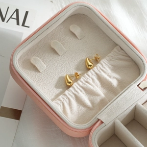 Polished gold teardrop earrings for women presented in a pink velvet jewelry storage case
