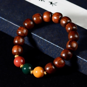 Detailed close-up of sandalwood beads with red, green, and yellow decorative accents