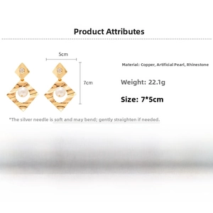 Detail view of geometric gold pearl earrings with rhinestone accents and silver needle post