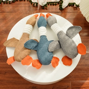 Detailed texture of grey, blue and brown plush goose pet toys on a white display stand