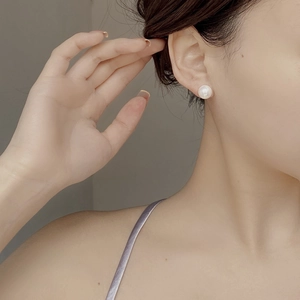 Lustrous white 925 sterling silver pearl stud earrings shown on model side profile view