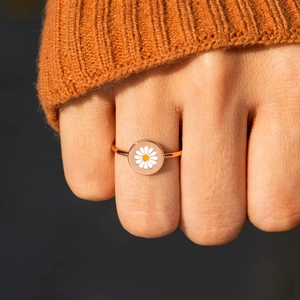 925 silver daisy ring in rose gold with white enamel flower on a finger model