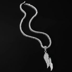 Close-up of hip hop silver wings pendant on a sparkling iced-out tennis chain necklace