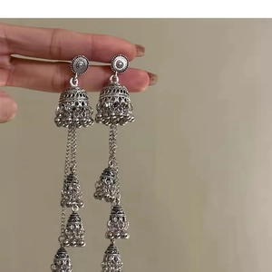 Detailed view of vintage silver bell-shaped tassel earrings with ethnic jhumka carvings