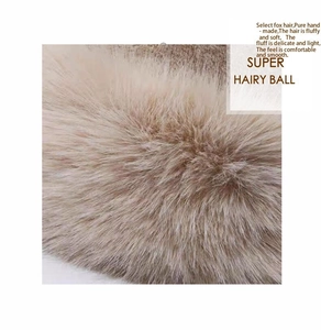 Close-up of soft khaki fox fur pompom detail with fluffy texture and handmade finish
