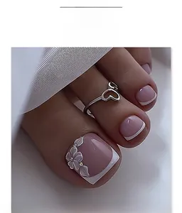 Detail of pink French press-on toenails with 3D embossed white flowers and small crystals