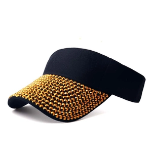 Detail of the black sun visor brim densely set with sparkling gold rhinestones