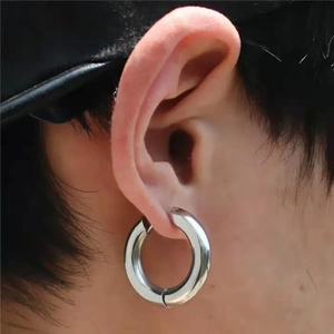 Close-up of a high-polished silver stainless steel hoop earring worn by a model