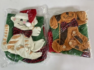 Detail of red and green plush Christmas pet stockings with 3D cat and dog motifs