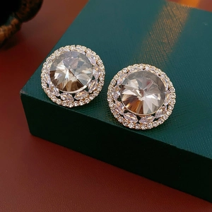 Macro view of champagne zircon round stud earrings with gold-plated claw setting