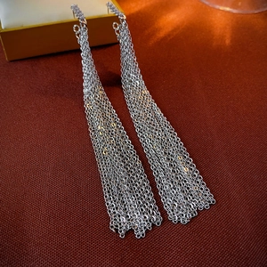 Macro shot of silver long fringe earrings showing multi-layered chain and metallic luster