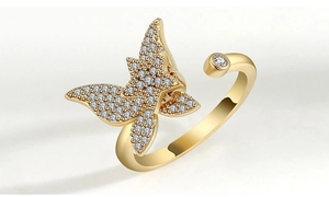 Macro shot of gold butterfly ring featuring crystal pavé wings and a round accent stone