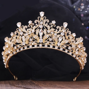 Detailed close-up of golden Baroque crown with sparkling rhinestones on dark background