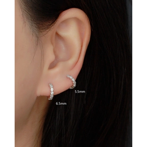 Detail view of 5.5mm and 6.5mm S925 sterling silver cz huggie earrings on ear