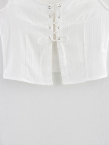 Detail of white ribbed lace-up camisole top with metal eyelets and tie-up front design