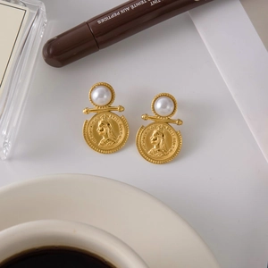 Detailed close-up of gold coin earrings with white pearls and Queen Victoria portrait