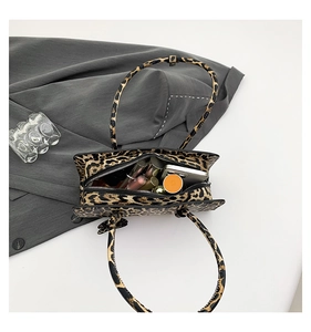 Top view of leopard print handbag interior showing lipstick and compact powder capacity