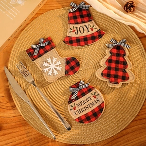 Plaid Christmas stocking and bell cutlery holders set on a rustic wooden table setup