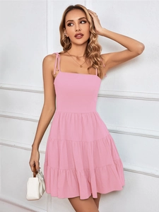 Detail of pink tiered sundress with adjustable shoulder ties and layered ruffle hem
