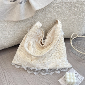 Close-up of beige crochet lace tote bag with floral cutout patterns and ruffled edges