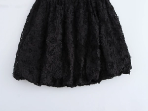 Detailaufnahme von schwarzer floraler Spitze und Ballonsaum am sexy trägerlosen Minikleid