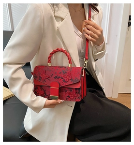 Détail du sac à main rouge brodé avec papillons 3D et poignée supérieure tissée