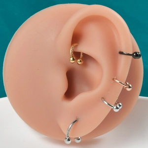 Horseshoe piercing set in gold and silver finish with white zircon inlay on ear model
