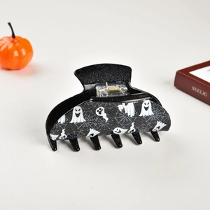 Detailed view of Halloween hair claw clip featuring white ghost and spider web patterns
