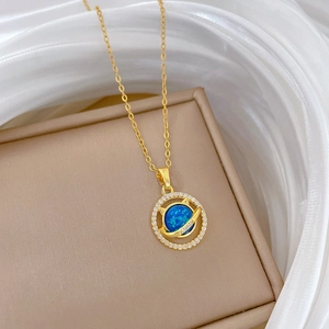 Detailed macro view of a gold-plated cat necklace featuring a blue opal stone and zircon pavé