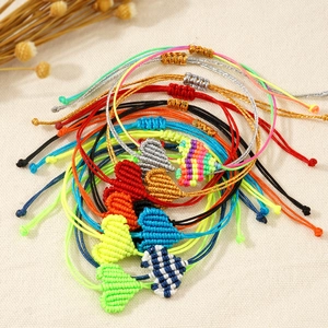 Dettaglio di braccialetti a cuore intrecciati a mano con cordini regolabili colorati