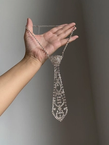 Close-up of a silver-tone rhinestone tie necklace with sparkling tassels and hollow mesh
