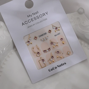 Macro detail of MJ-057 nail art charms with pink gems and gold bow accents on porcelain