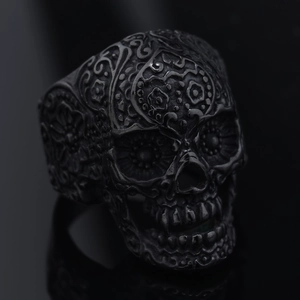Macro detail of gothic matte black sugar skull ring with intricate floral engravings